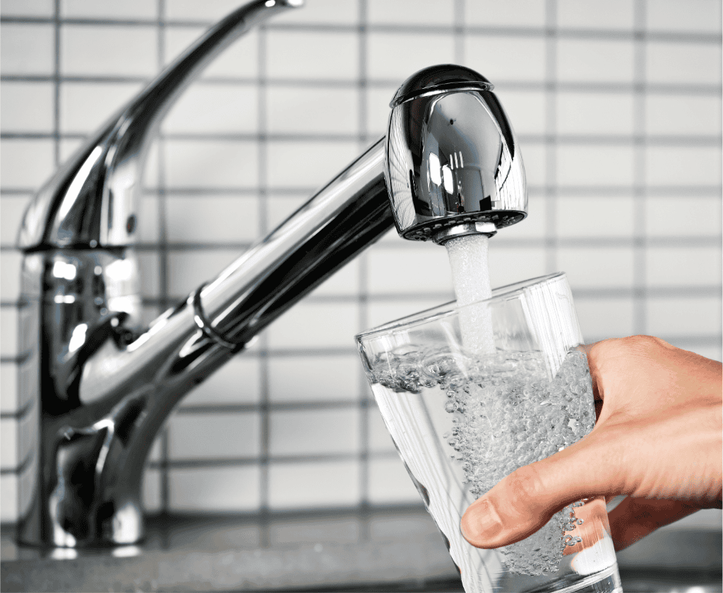 Glass of water being filled directly from tap